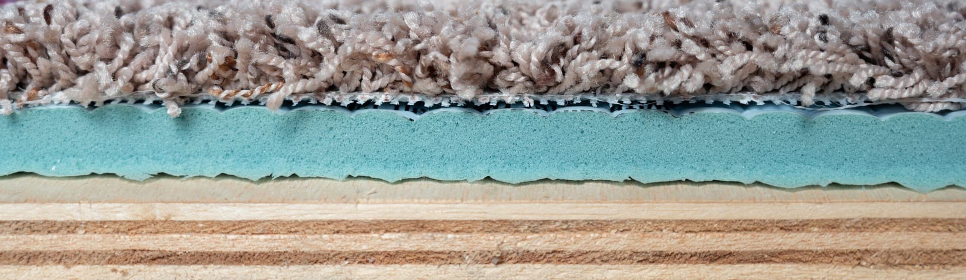 Close view of carpet fibers, backing, and a separate cushion